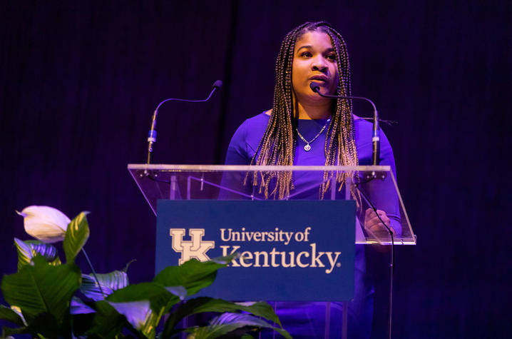 female student speaking at podium on stage 