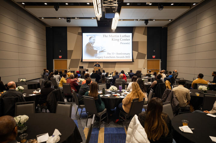 Large ballroom with audience looking at award presentation on screen above stage