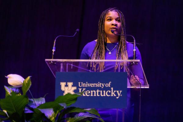 female student speaking at podium on stage 